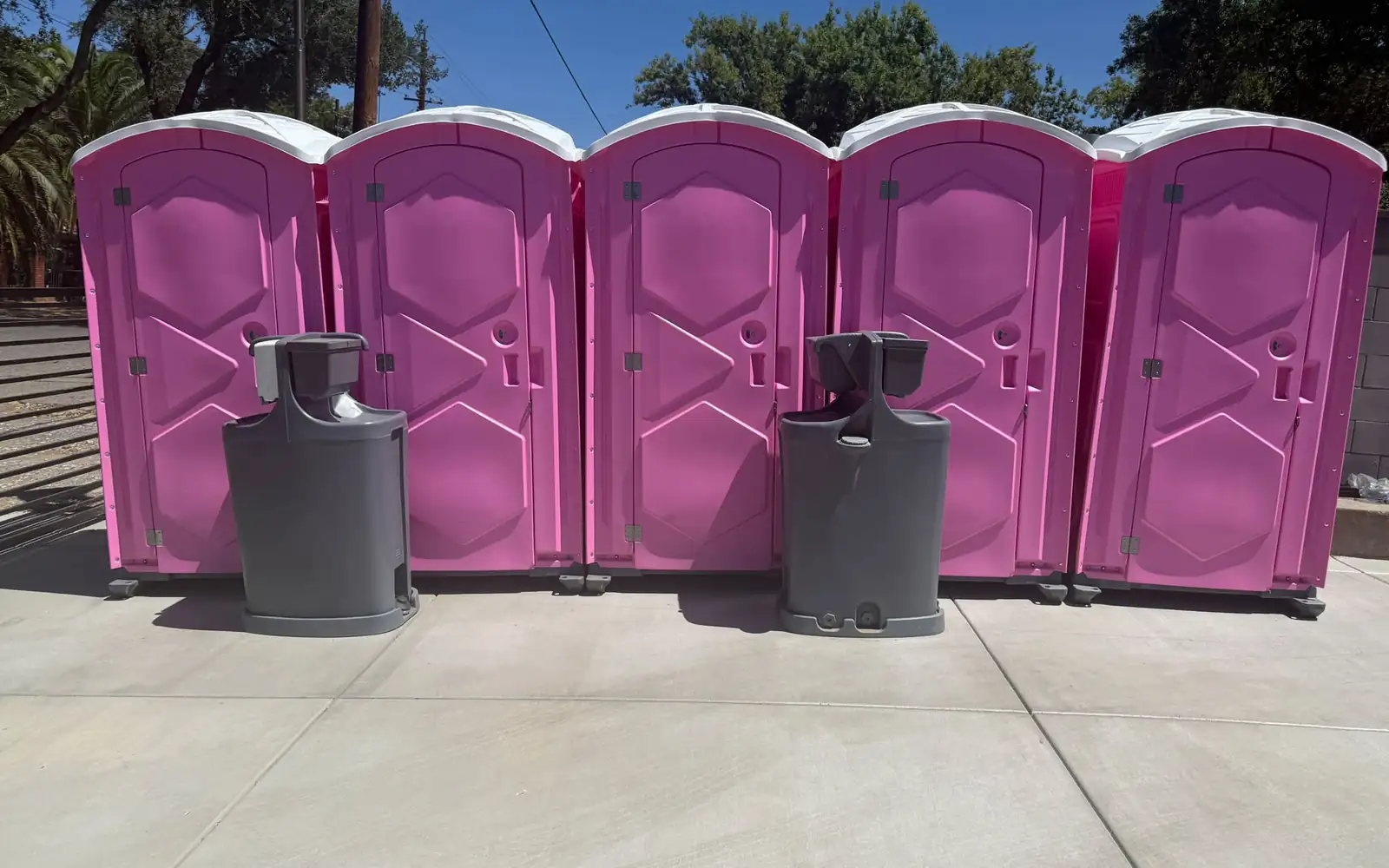 Close-up of a porta potty toilet seat with lid and a urinal inside a unit