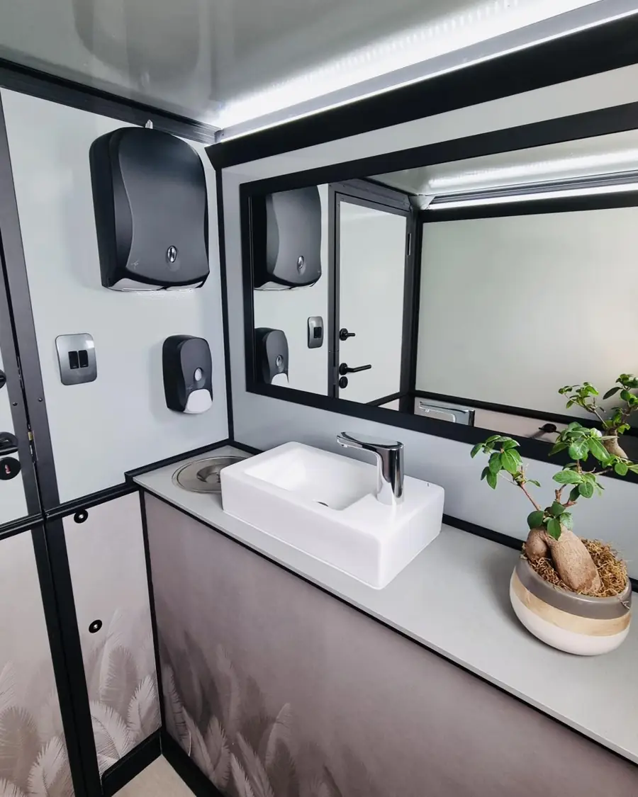Restroom trailer vanity with sink, mirror, towel and soap dispensers